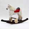 Houpací kůň vyrobený z borového dřeva nabarvený jako bělouš s podstavcem pod nohy dítěte
