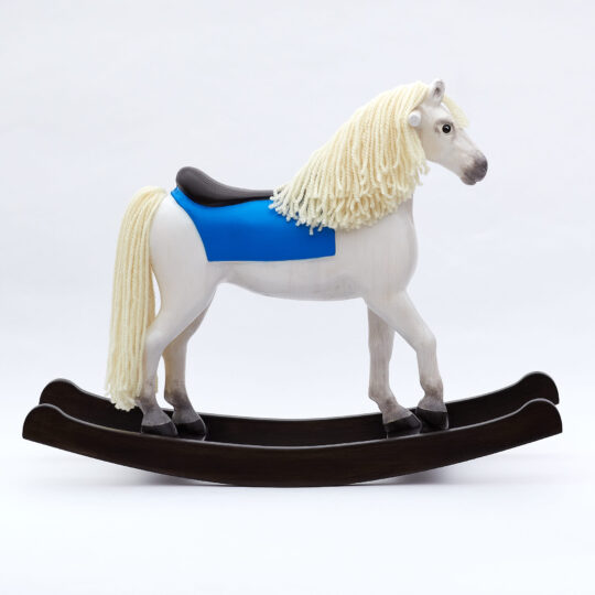 Dřevěný houpací kůň střední velikosti s dřevěným sedlem bělouš s modrým přehozem